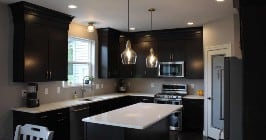 Kitchen with black cabinets and white counters